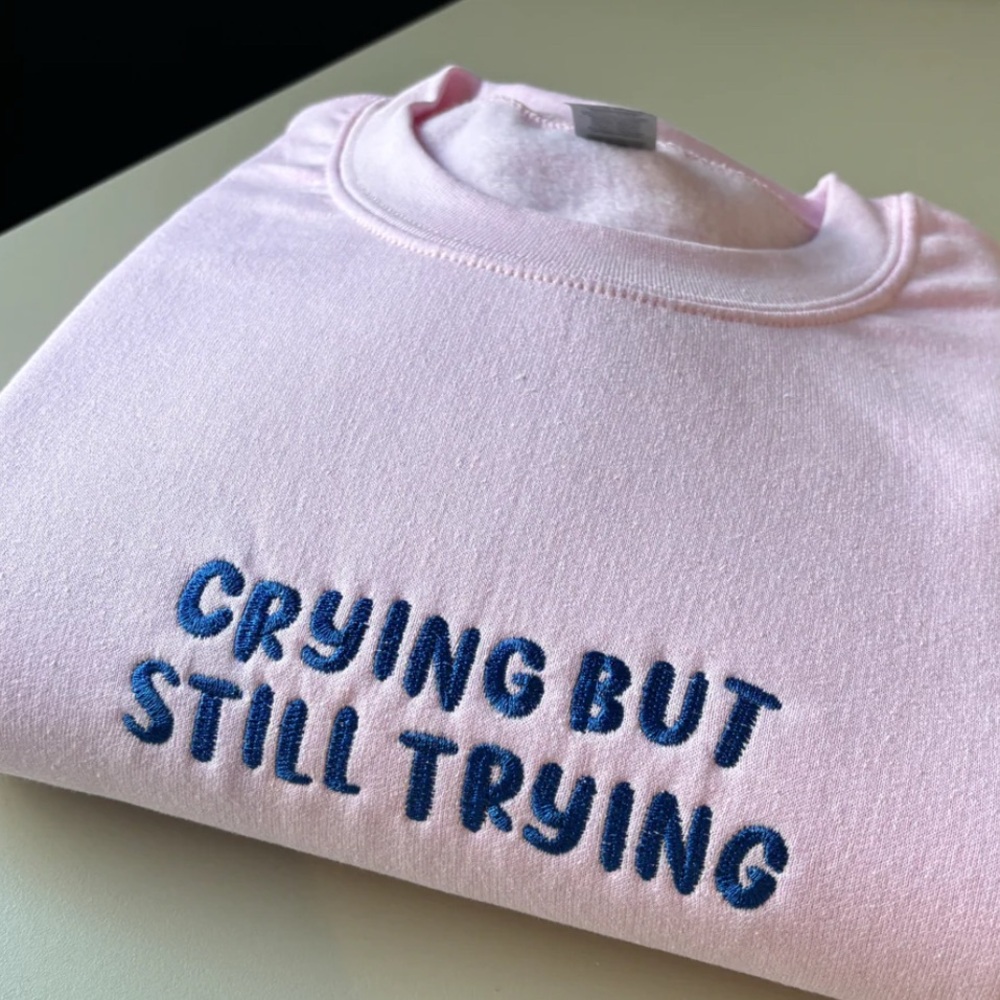 CRYING BUT STILL TRYING EMBROIDERED SWEATSHIRT